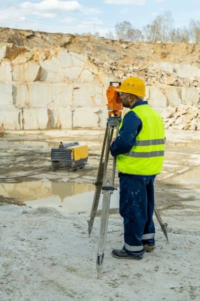  Licensed land surveyor using equipment to collect measurements for a flood elevation survey
