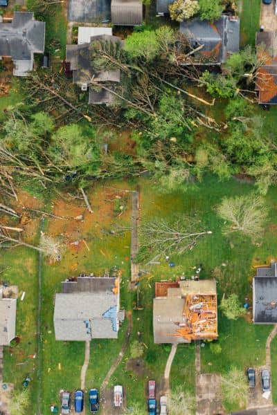 Drone surveyors aerial storm damage mapping - ALTA SURVEY Maine Aerial drone view of storm damage showing fallen trees and roof destruction used for mapping and recovery surveys.