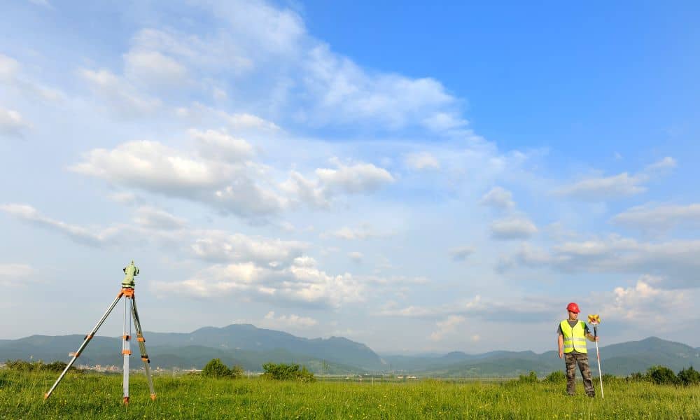 A land surveyor using professional equipment to map an open field during a property survey
