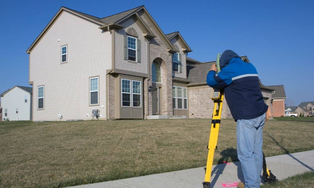 Land surveyor marking boundary lines on a residential property during a property line survey