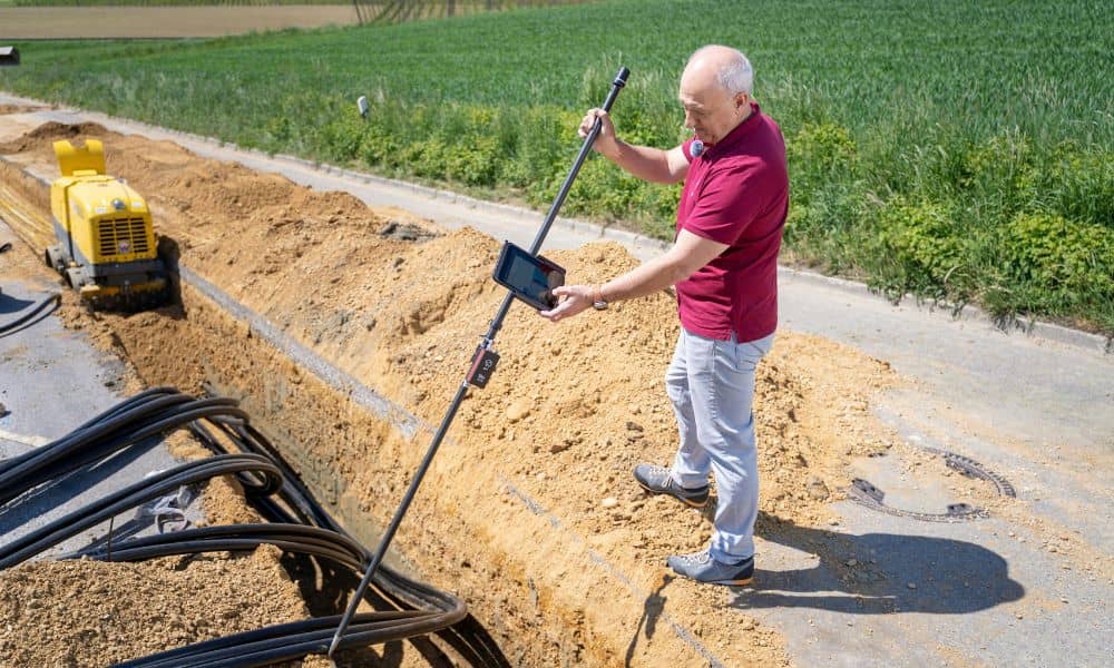Construction survey crew verifying underground utility lines before excavation work