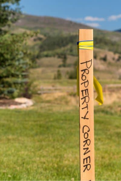 Property corner marker stake used in land surveying to show boundary location and how missing markers can affect land survey cost